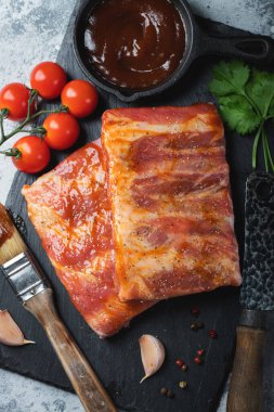 Barbekü, çiğ domuz pirzolası ve barbekü sosu hazır. Siyah arka plan. Üst görünüm.