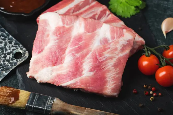 Çiğ et. Sırtından çiğ domuz kaburgası ve siyah bir arka planda et. arkaplan resmi, boşluk metni kopyala