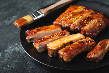 Barbekü soslu bir tabakta servis edilen sıcak ızgara pirzola. Üst Manzara. Boşluğu kopyala.