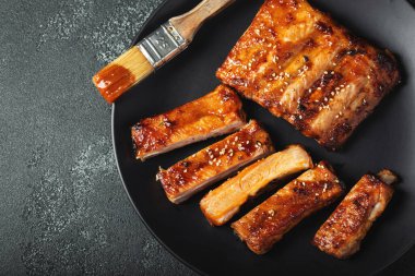 Barbekü soslu bir tabakta servis edilen sıcak ızgara pirzola. Üst Manzara. Boşluğu kopyala.