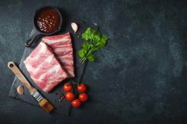 Çiğ et. Sırtından çiğ domuz kaburgası ve siyah bir arka planda et. arkaplan resmi, boşluk metni kopyala