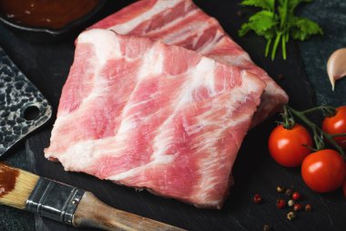 Çiğ et. Sırtından çiğ domuz kaburgası ve siyah bir arka planda et. arkaplan resmi, boşluk metni kopyala