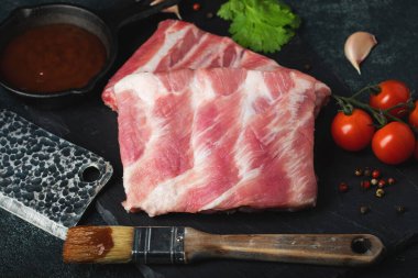 Çiğ et. Sırtından çiğ domuz kaburgası ve siyah bir arka planda et. arkaplan resmi, boşluk metni kopyala