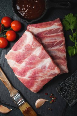 Çiğ et. Sırtından çiğ domuz kaburgası ve siyah bir arka planda et. arkaplan resmi, boşluk metni kopyala