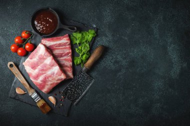 Çiğ et. Sırtından çiğ domuz kaburgası ve siyah bir arka planda et. arkaplan resmi, boşluk metni kopyala