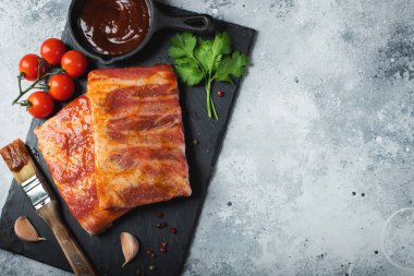 Barbekü, çiğ domuz pirzolası ve barbekü sosu hazır. Siyah arka plan. Üst görünüm.