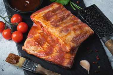 Barbekü, çiğ domuz pirzolası ve barbekü sosu hazır. Siyah arka plan. Üst görünüm.