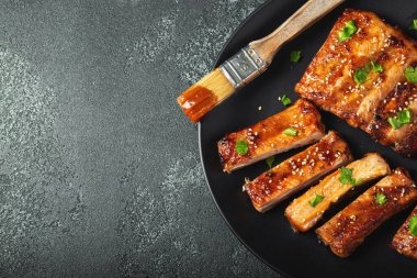 Barbekü soslu bir tabakta servis edilen sıcak ızgara pirzola. Üst Manzara. Boşluğu kopyala.