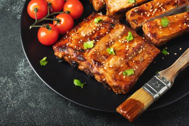 Barbekü soslu bir tabakta servis edilen sıcak ızgara pirzola. Üst Manzara. Boşluğu kopyala.