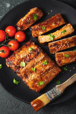 Barbekü soslu bir tabakta servis edilen sıcak ızgara pirzola. Üst Manzara. Boşluğu kopyala.