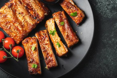 Barbekü soslu bir tabakta servis edilen sıcak ızgara pirzola. Üst Manzara. Boşluğu kopyala.