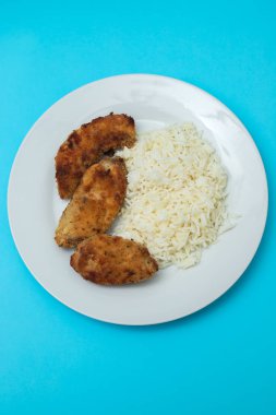 Lezzetli kızarmış tavuk göğsü şeritleri ve kaynamış pirinç.