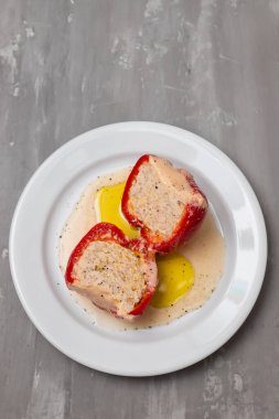 Et, sebze, peynir ve otlarla doldurulmuş kırmızı biberler seramik bir zeminde. Lezzetli ev yemekleri.