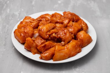 Marinating meat with spices and onion on white plate