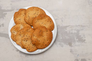 Açık kahverengi tabakta seramik üzerinde izole edilmiş tereyağlı kurabiyeler.