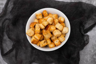 Crispy dry cubes of white bread in white bowl