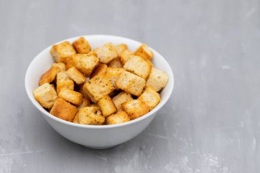 Crispy dry cubes of white bread in white bowl