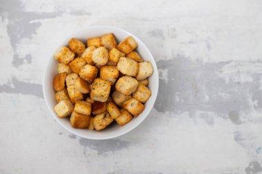 Crispy dry cubes of white bread in white bowl