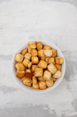 Crispy dry cubes of white bread in white bowl