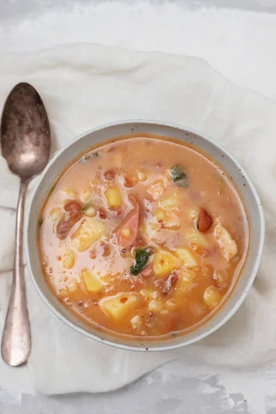 Sopa de pedra Portuguese Stone Soup with beans and sausages in the plate on gray ceramic