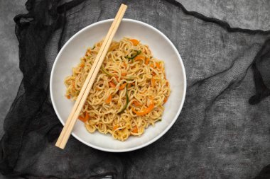 Büyük bir kasede sebzeli taze erişte.