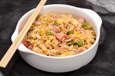 Rice with corn. peas, ham on white small bowl