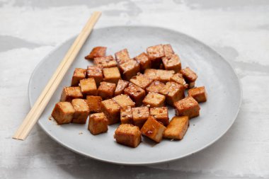 crispy deep stir fried tofu cubes on small white dish