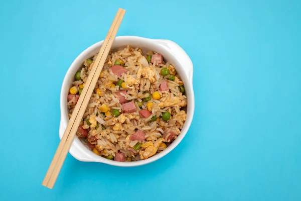 Rice with corn. peas, ham on white small bowl