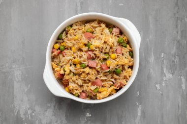 Rice with corn. peas, ham on white small bowl