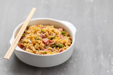 Rice with corn. peas, ham on white small bowl