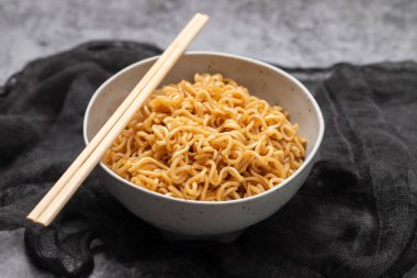 Fresh tasty noodles with vegetables in white big bowl on ceramic