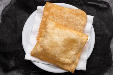 typical brazilian fried pastry on white small plate