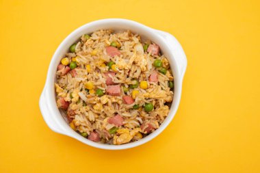 Rice with corn. peas, ham on white small bowl