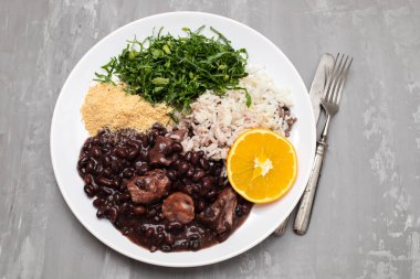 black beans stew with sausages on a big white dish