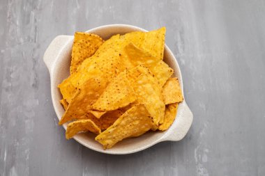 Few mexican nachos chips in small bowl on ceramic