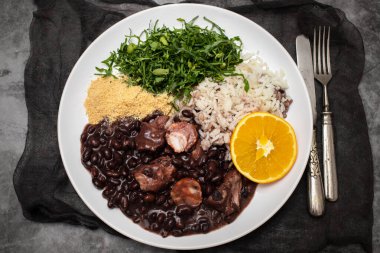 black beans stew with sausages on a big white dish