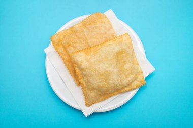 typical brazilian fried pastry on white small plate