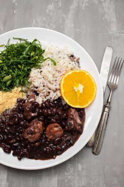 black beans stew with sausages on a big white dish