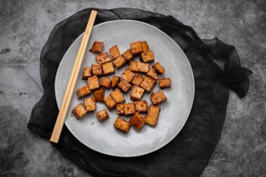 crispy deep stir fried tofu cubes on small white dish