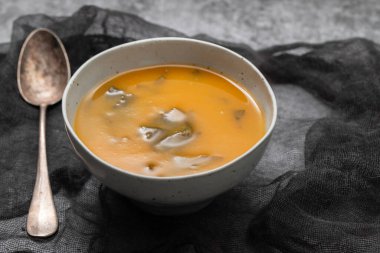 Vegetable cream soup with spinach in small bowl on paper
