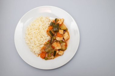 squid stew with vegetables and boiled rice on white plate