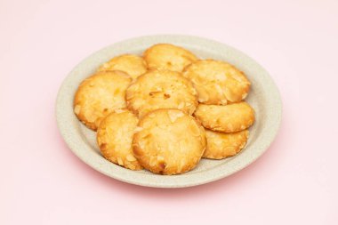 Beyaz küçük tabakta bademli birkaç ev yapımı kurabiye.