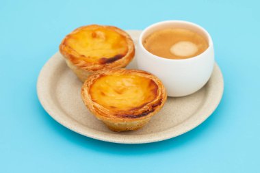 Yumurtalı tart, geleneksel Portekiz tatlısı, pastel de nata ve bir fincan kahve.