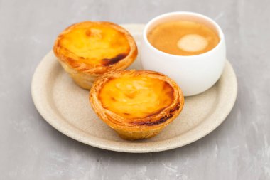 Yumurtalı tart, geleneksel Portekiz tatlısı, pastel de nata ve bir fincan kahve.