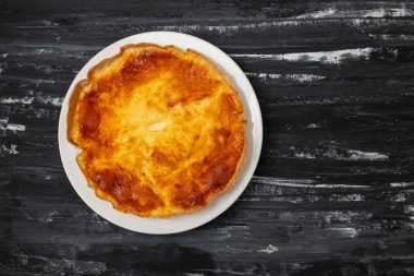 Beyaz tabakta sebzeli ve peynirli ev yapımı kiş tartı.