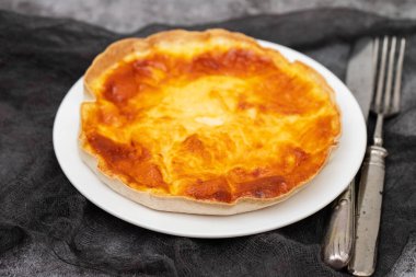 Beyaz tabakta sebzeli ve peynirli ev yapımı kiş tartı.