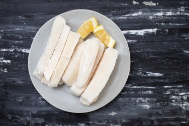 Tabağında limon olan taze donmuş mürekkep balığı.