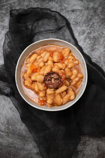 Tipik Portekiz yemek dobradası, koyu arkaplanda seramik kasede fasulye.