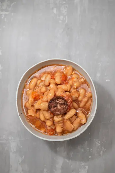 typical portuguese dish dobrada with beans in ceramic bowl on dark background