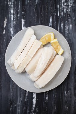 Tabağında limon olan taze donmuş mürekkep balığı.